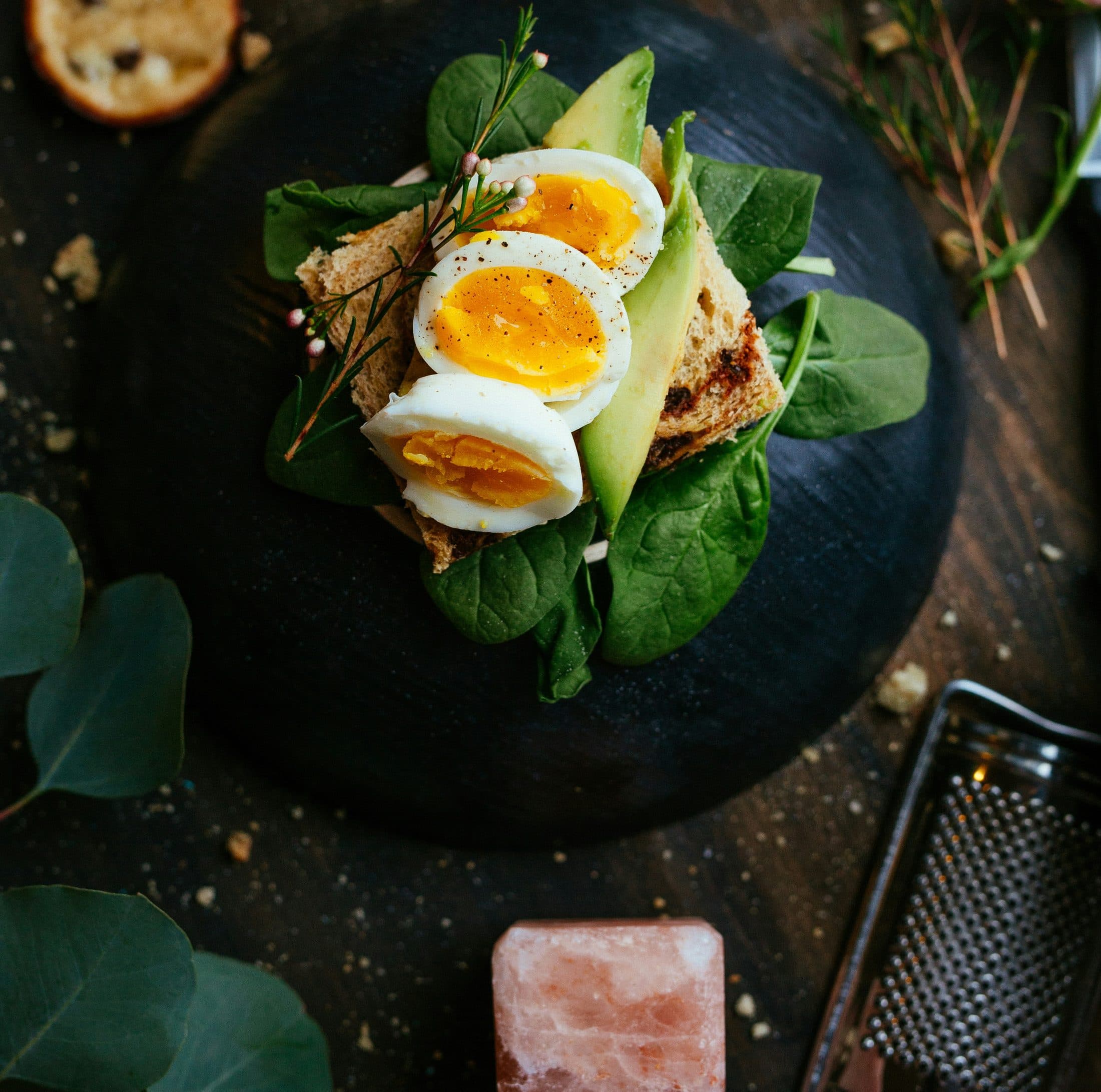 Avocado toast with egg on a dark slate surface